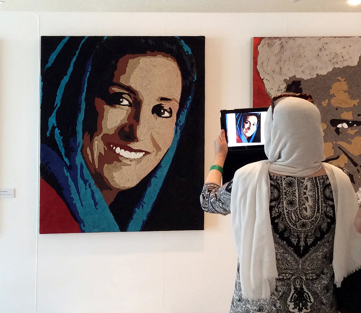 Visitor photographing a fresco portrait by Fabrizio Ruggiero
